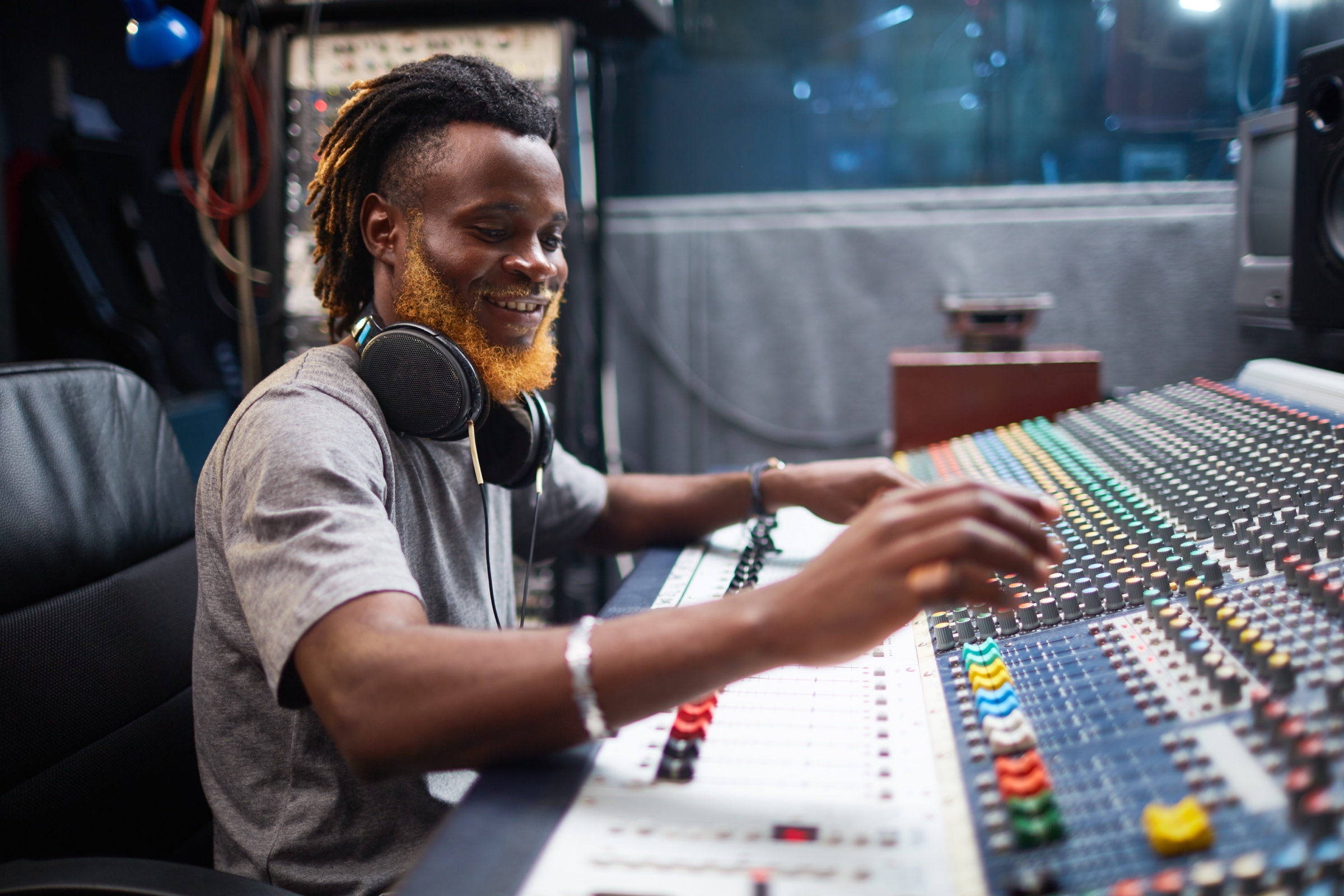 Audio engineer mixing music at a sound board in a recording studio