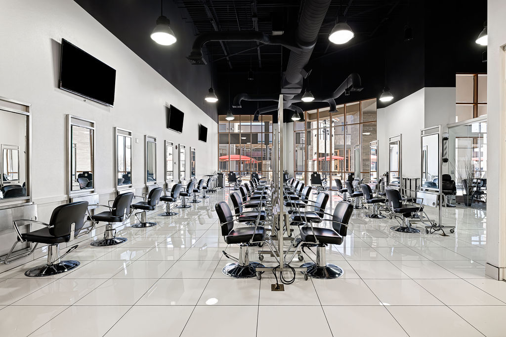 Clinic floor with rows of barber chairs and stations